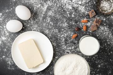 Raw food ingredients for baking and cupcake form on dark background, prepare for cooking, top view