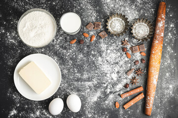 Raw food ingredients for baking and cupcake form on dark background, prepare for cooking, top view