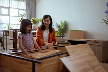 mother and daughter assembling new furniture together