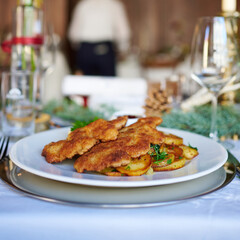 Sehr leckeres Wiener Schnitzel mit Krosser Panade und Bratkartoffeln und Preiselbeer serviert in einem Restaurant Wirtshaus