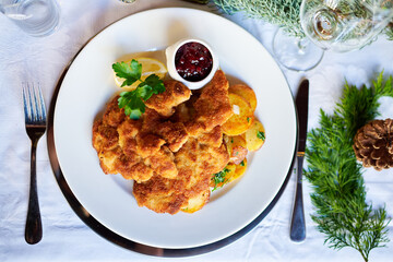 Sehr leckeres Wiener Schnitzel mit Krosser Panade und Bratkartoffeln und Preiselbeer serviert in...