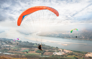 Paragliding in the sky. Paraglider  flying over Landscape from Beautiful View Mekong River at Wat...