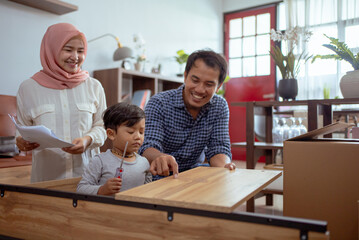 Fototapeta premium muslim family and son assembling new furniture