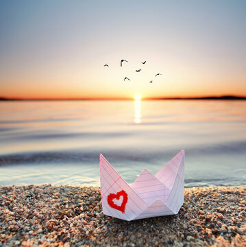 romantisches Papierboot am Strand