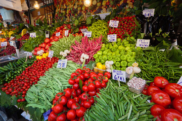 Fototapeta na wymiar Fresh vegetables: tomatoes, green beans, peppers, garlic, herbs in the market window. Istanbul, Turkey.