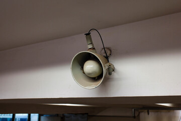 Grey loudspeaker hanging from the ceiling. 