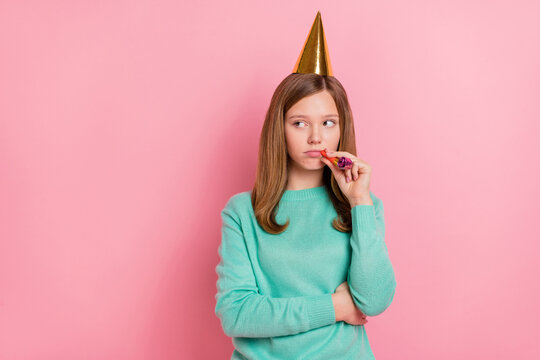 Photo of unhappy upset girl wear turquoise sweater birthday headwear holding whistle isolated pink color background