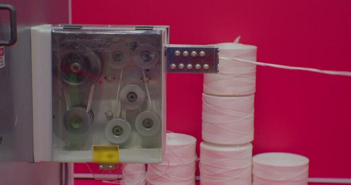 modern industrial equipment.Weaving mashine For The Production Of Plastic Or Polypropylene Bags . Rows Of White Reels With Ropes Making Plastic Sacks In A Modern Production Plant.