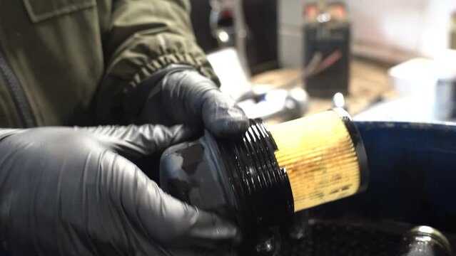 A technician changes an oil filter element