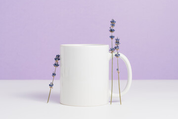 White mockup mug for branding, design or text with purple background. Trendy lavender color of the...