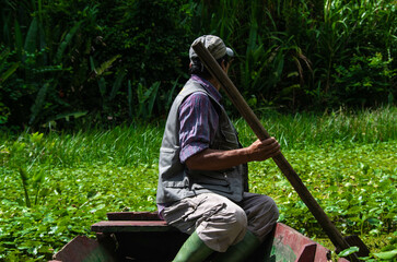 Homme dans une barque sur les rives de la forêt amazonienne dans le parc madidi en bolivie