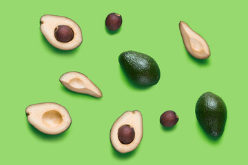 Set for designer from avocado pieces. Collection whole and half avocados and avocado’s seeds for design isolated on green background. Topview, flatlay
