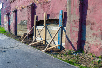 retaining wall made of boards serves as a formwork for a concrete patch in a wall collapsing from...