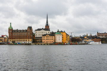 Fototapeta premium Stockholm, Sweden. Overview of Gamla Stan old town with the baltic sea in the foreground. Cloudy day in Sweden.