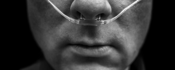 Dramatisch wirkende Aufnahme eines kranken Mannes mit Sauerstoffbrille - obrazy, fototapety, plakaty