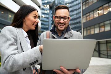 Happy business people smiling talking in the city. Work success people concept