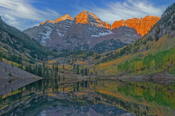 Autumn landscape at sunrise of the Maroon Bells mirrored in calm water, Maroon Bells Snowmass...