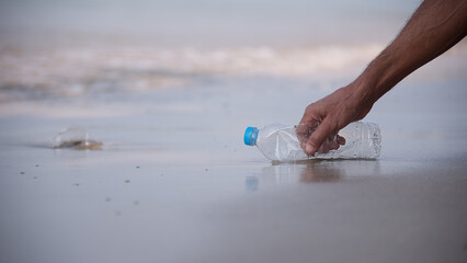 Volunteer hands collect plastic bottles on the beach, Garbage collection to keep it clean, Recyclable waste world environment day and environmentally friendliness or eco friendly or ecology concept.