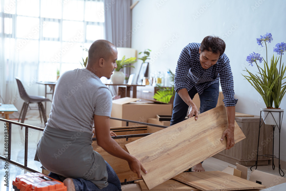 Wall mural two male woodworker assembling new furniture together