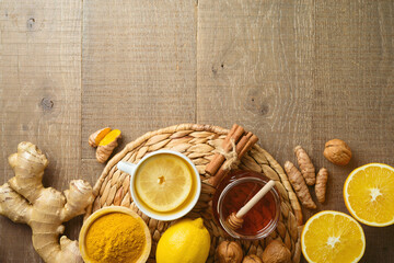 Immunity boosting tea and healthy ingredients on wooden table background. Top view with copy space