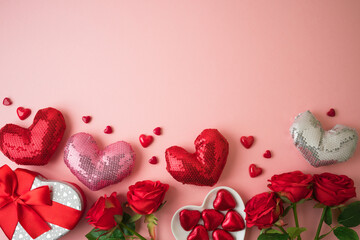 Valentines day concept with heart shapes, gift box and rose flowers on pink background. Top view