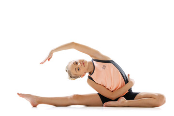 Portrait of sportive beautiful little girl, rhythmic gymnastics artist doing flexible exercises isolated on white studio background. Grace in motion, action.