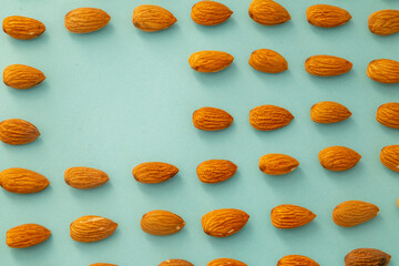 Almonds isolated. Walnuts on green background. Brazilian nuts Almond. Arranged on a light green background. Macro. Copy space