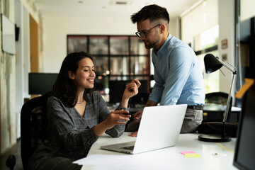 Colleagues in office. Businesswoman and businessman discussing work in office.