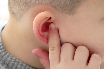 earache in children,a child holding his ear,child suffering from earache,ear inflammation,