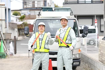Fotobehang 誘導棒を持つ交通誘導をする作業服姿の男性達 © koumaru