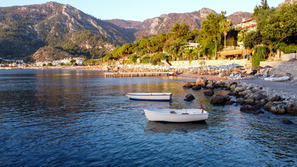 Sea bay surrounded by mountains and rocks in small touristic village Turunc. Seascape with boats moored in calm water. - obrazy, fototapety, plakaty