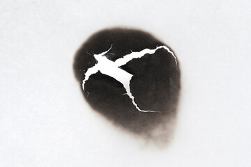 Burnt hole isolated on white paper. burns borders paper close up