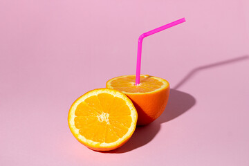 The concept of fresh natural orange juice. Sliced orange on a pink background. refreshing drink
