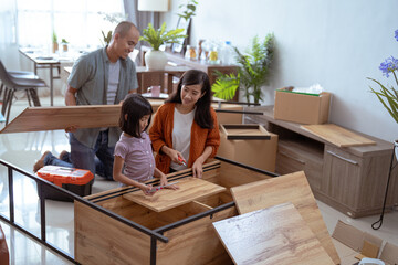 asian family at their new house buying and assembling new furniture.