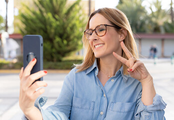 Portrait of a beautiful young woman standing outside using mobile phone