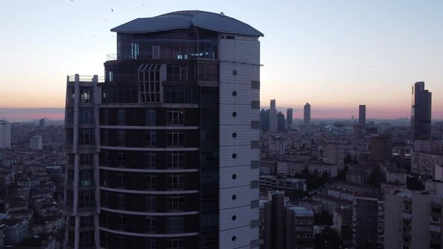 Drone flight behinds a building and revealing a sun setting in turkey