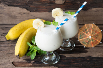 Banana fresh cocktail vanilla smoothies  fruit juice beverage healthy the taste yummy in glass drink episode good morning on wooden background.