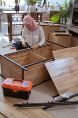 Fototapeta premium muslim woman assembling new furniture at home