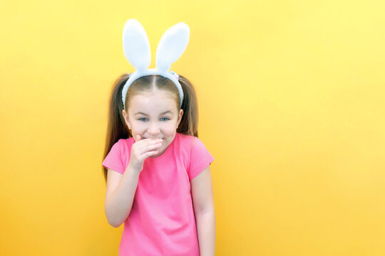 cheerful girl with rabbit ears on her head on a yellow background. Funny crazy happy child. Easter child. Preparation for the Easter holiday. promotional items. copy space