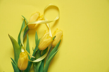 Five yellow fresh tulips on a yellow background. Flowers with the number eight made of ribbon. Concept of holiday, March 8, International womans day. Card with copy space.