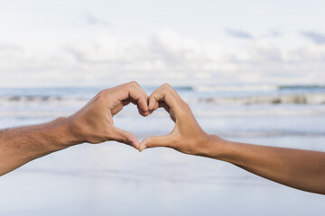 Couple hands making heart shape, symbol of love.