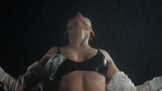 Hot young woman with nice body under the rain wearing wet shirt