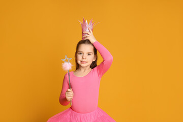 Cute girl in pink crown with magic wand on yellow background, space for text. Little princess