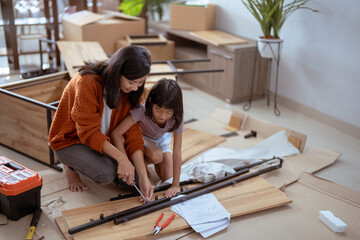 mother and daughter assembling new furniture together