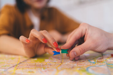 ?ouple pointing with notice board pins on city map
