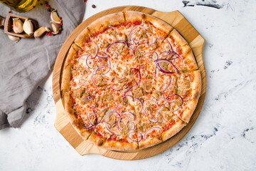 Pizza with tuna and red onion on the board on grey table top view