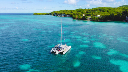 Bateau de tourisme trimaran sur une eau turquoise en Guadeloupe à Marie-Galante
