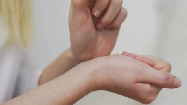 Close-up of an unrecognizable girl applying perfume on her wrist