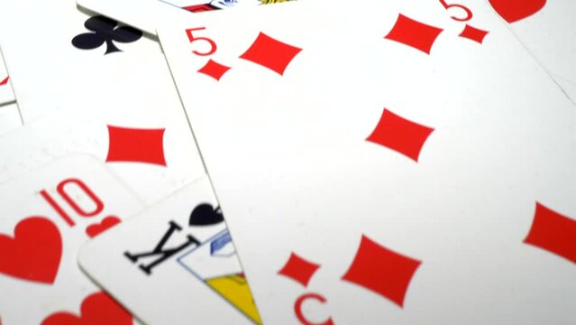 Closeup overhead dolly shot of playing cards randomly spread out.