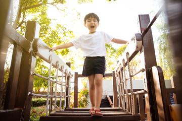 Happy Asian little boy enjoy playing and walking at the park with daddy.